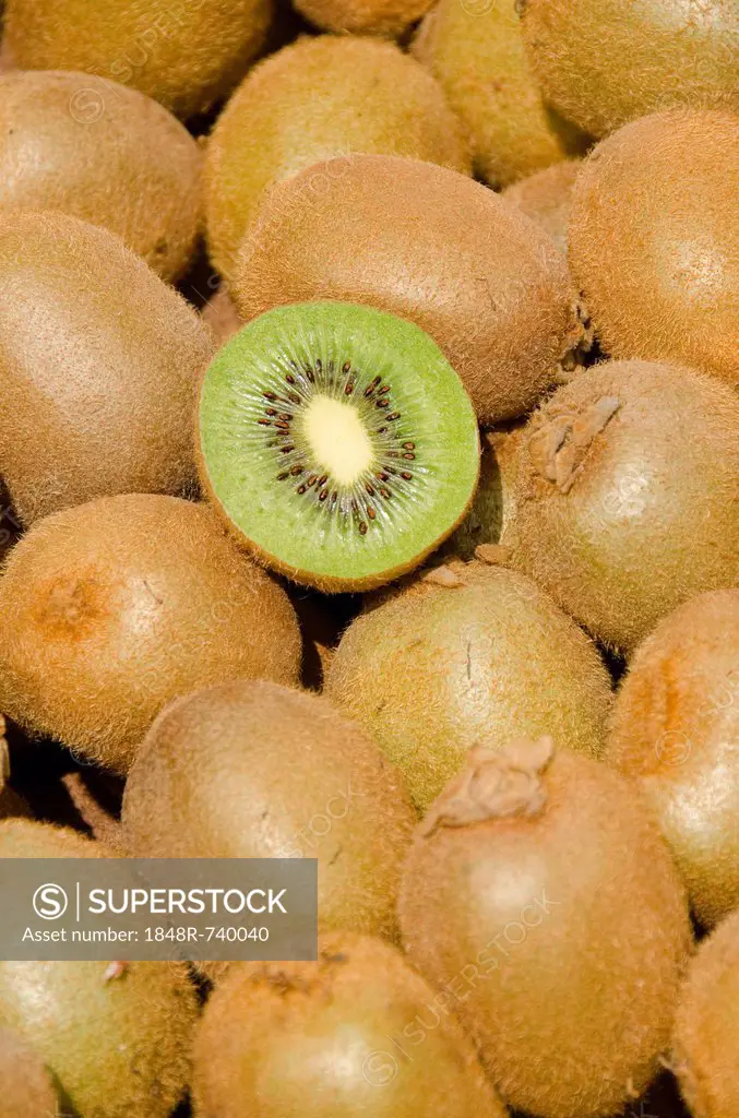 Kiwifruits (Actinidia deliciosa), one cut open