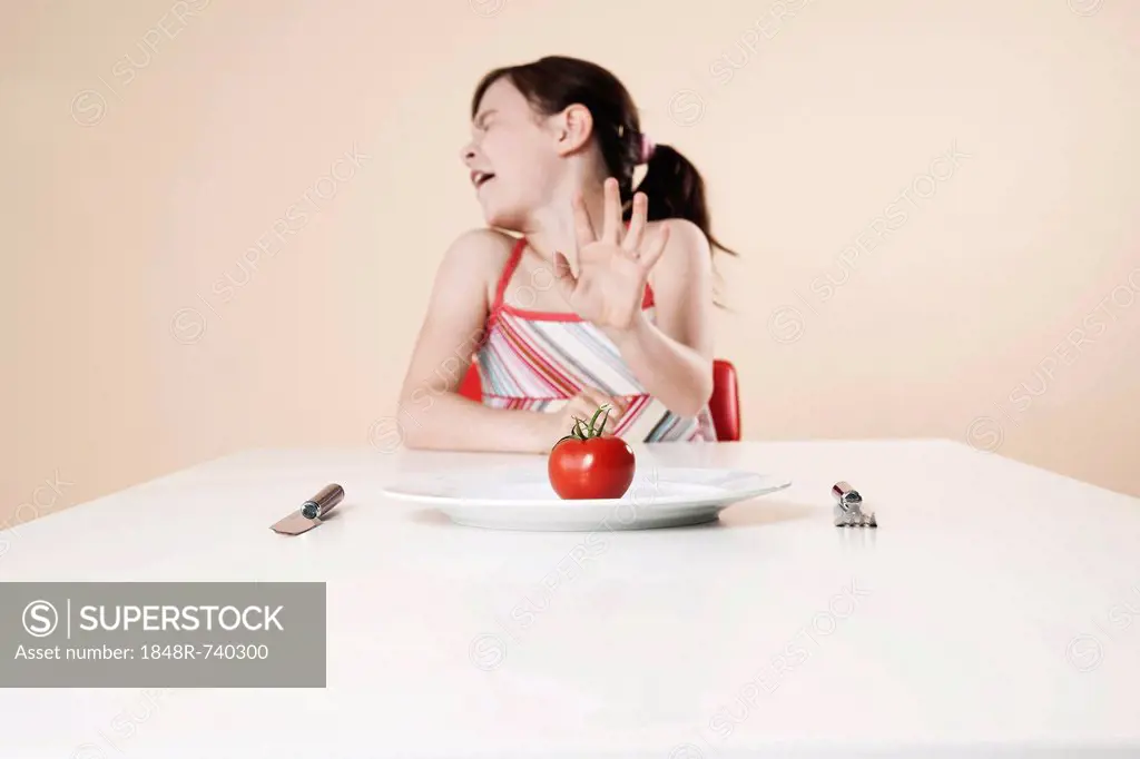 Girl turns away in disgust from a tomato