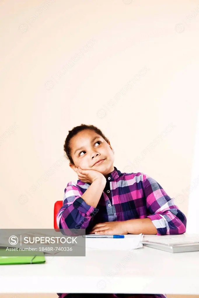 Girl sitting and thinking at her desk