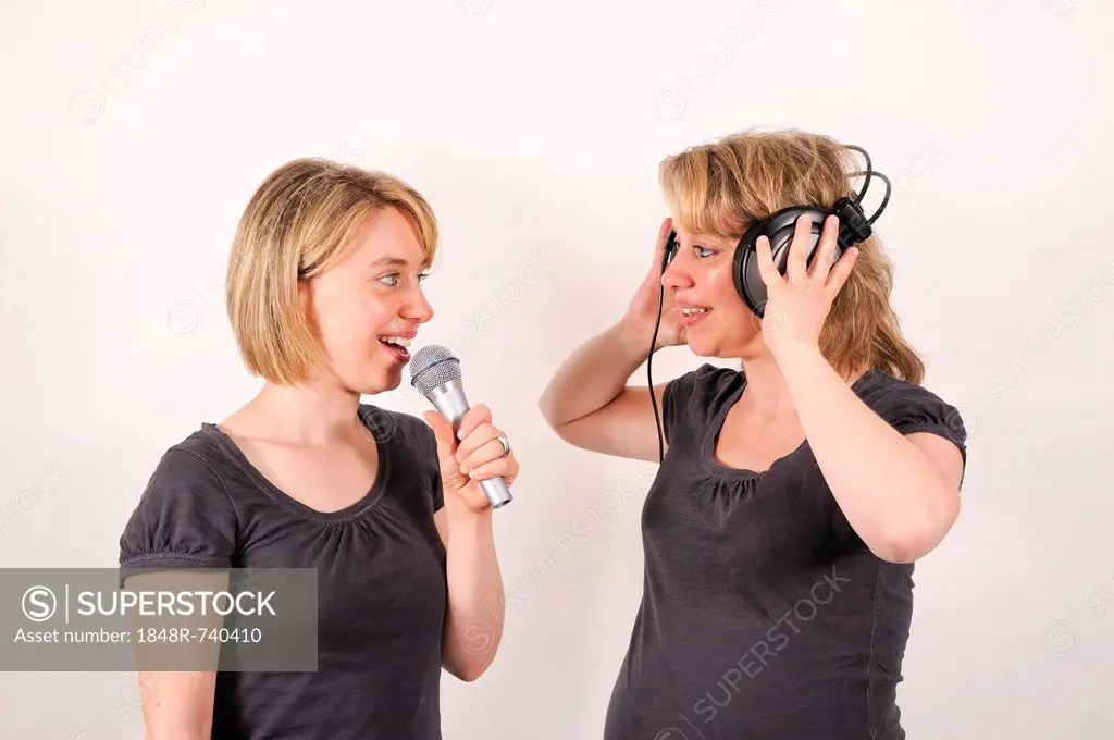 Twin sisters with a microphone and headphones