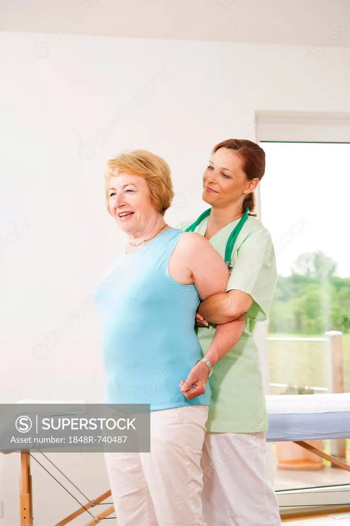 Woman being treated on her shoulder by a physiotherapist