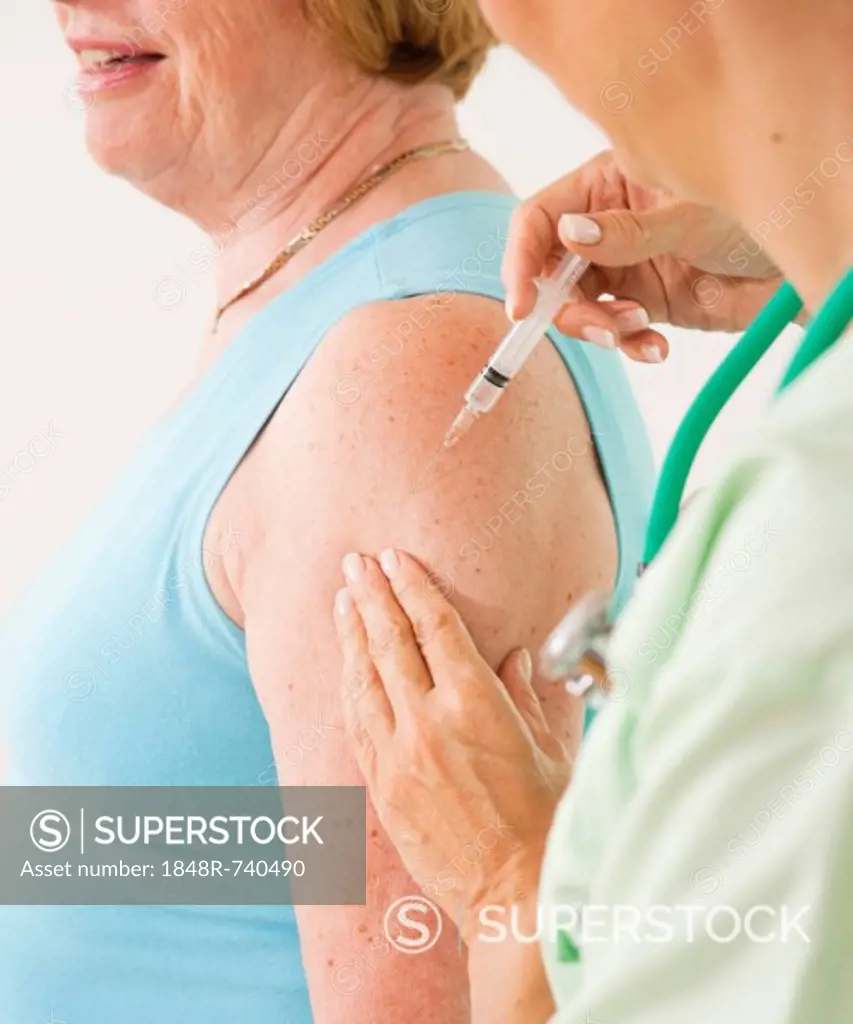 Patient receiving an injection from her doctor, vaccination