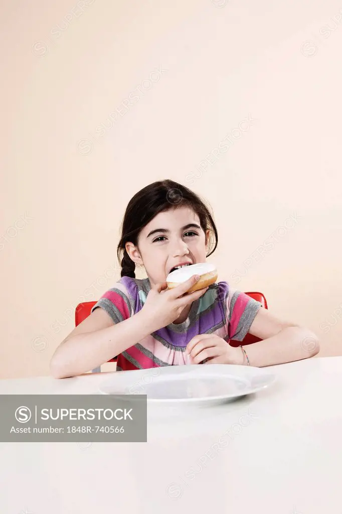 Girl hungrily eating a donut
