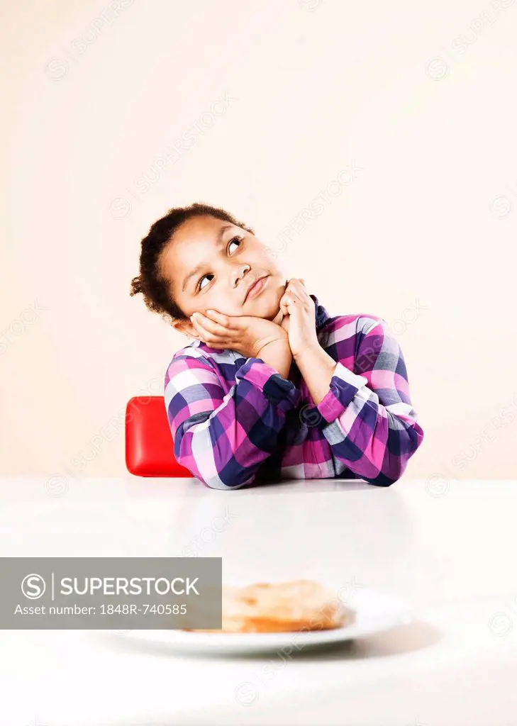 Girl considering whether to eat a piece of sweet pastry