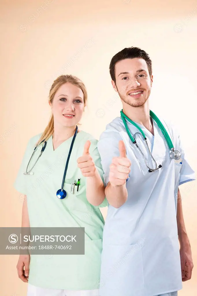 Male and female nurses giving a thumbs-up gesture
