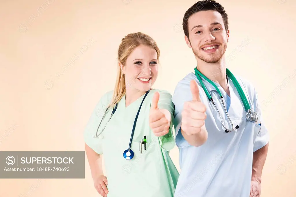 Male and female nurses giving a thumbs-up gesture