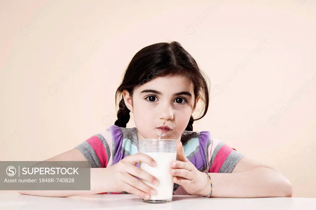Girl with a glass of milk in her hand