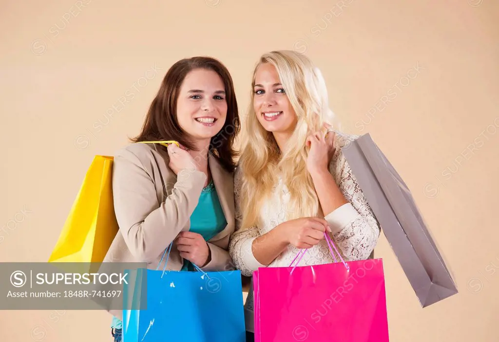 Girlfriends with shopping bags while shopping together