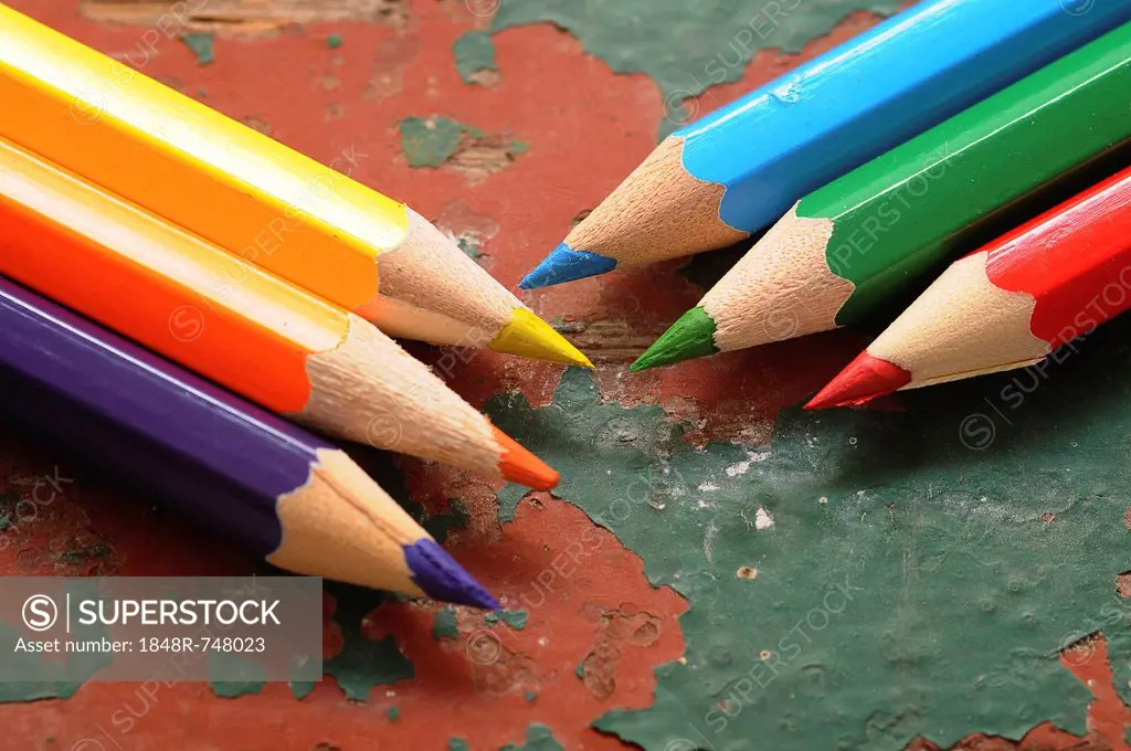 Wooden coloured pencils on an old wooden board