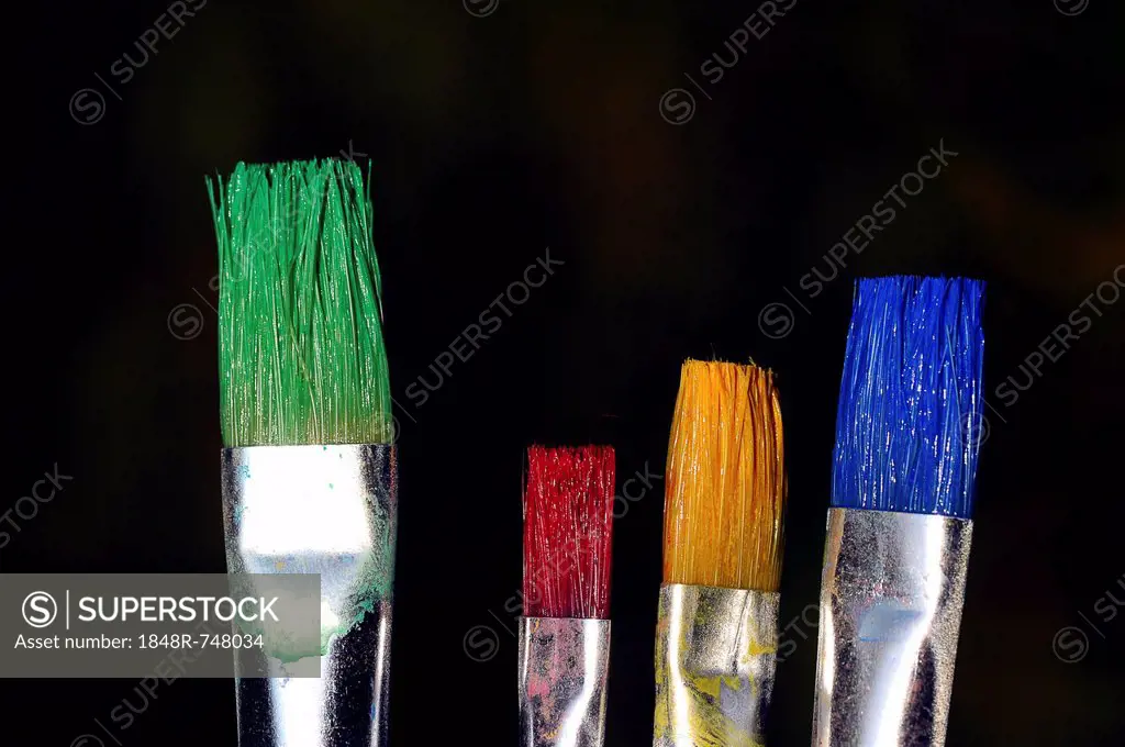 Bristle brushes with green, red, yellow and blue paint