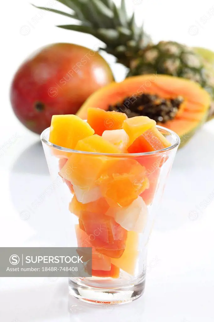 Tropical fruit from a tin can presented in a glass, pineapple, papaya, mango