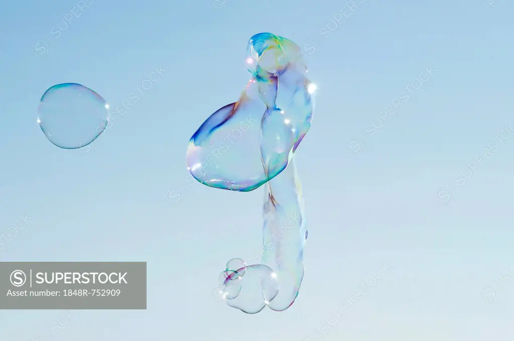 Large soap bubbles in front of a bright blue sky
