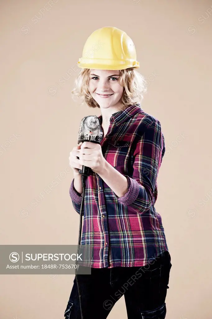 Girl wearing a hard hat and holding a drill