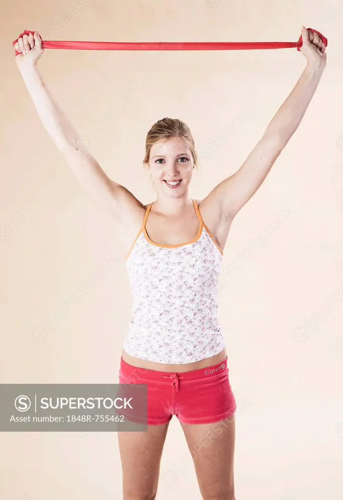 Young woman doing exercises with a Theraband