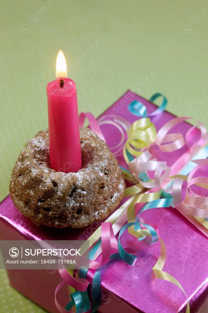 Small birthday cake with a candle on a birthday present
