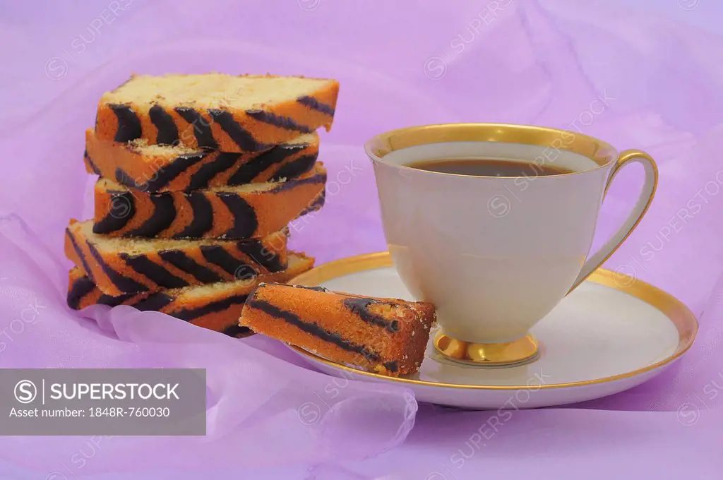 Coffee cup with a gold rim, slices of ring cake