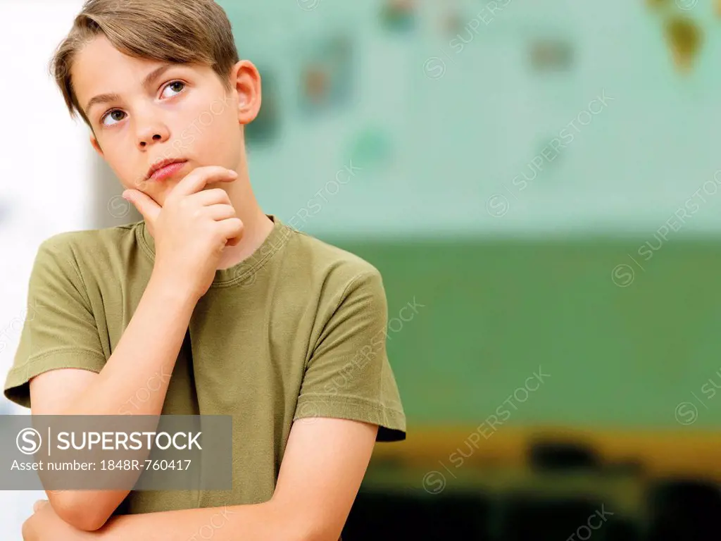 Schoolboy looking thoughtful in a classroom