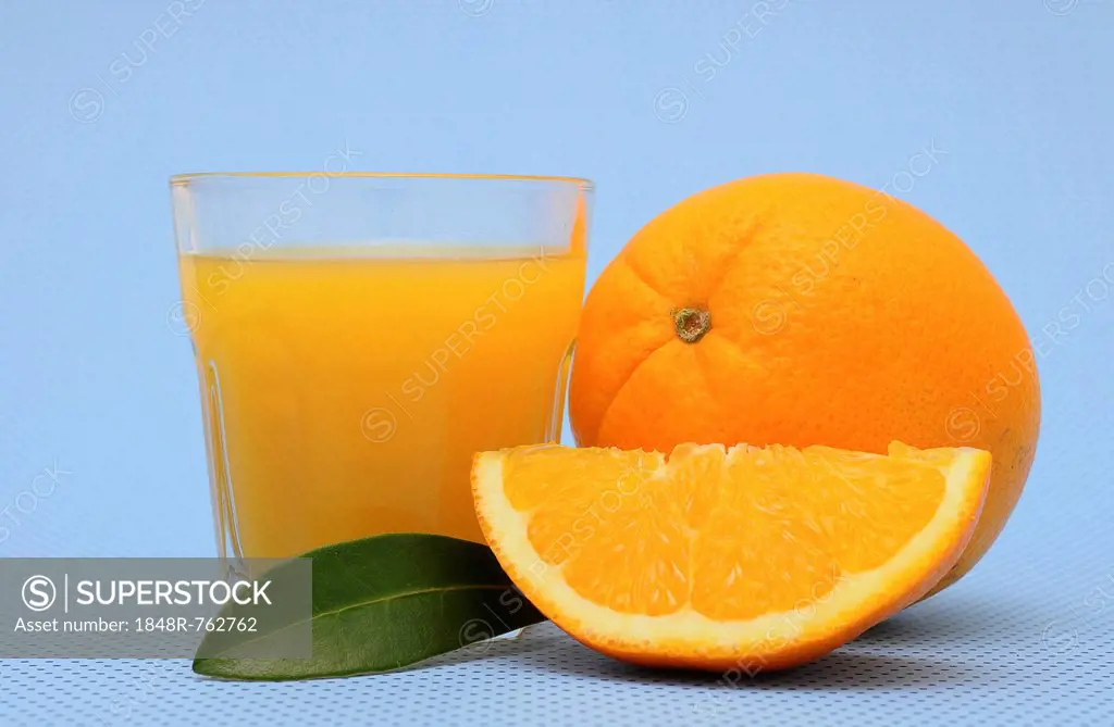 Freshly squeezed orange juice, an orange and an orange quarter