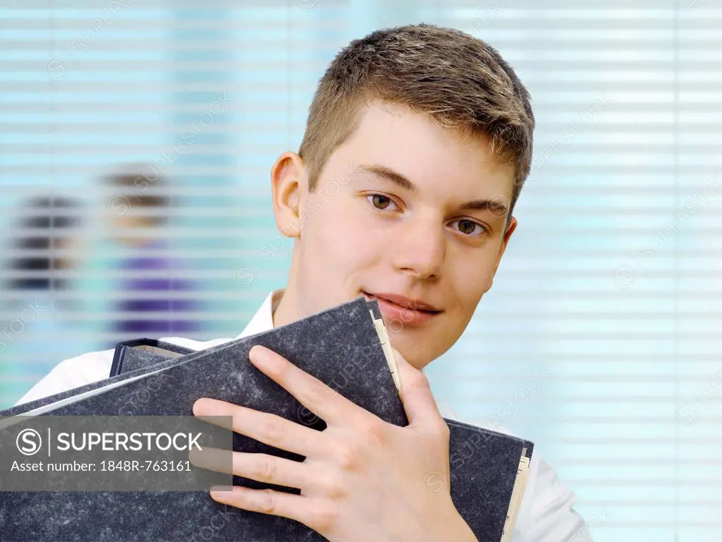 Apprentice or trainee holding files in an office