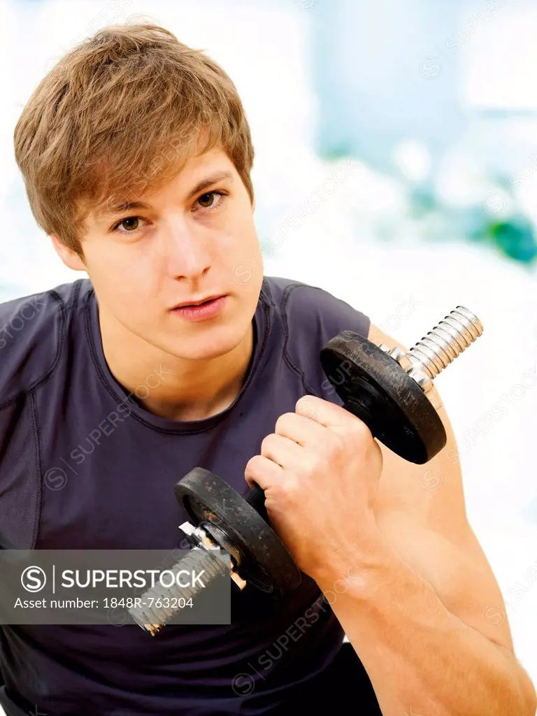 Young man doing strength training with a dumbbell