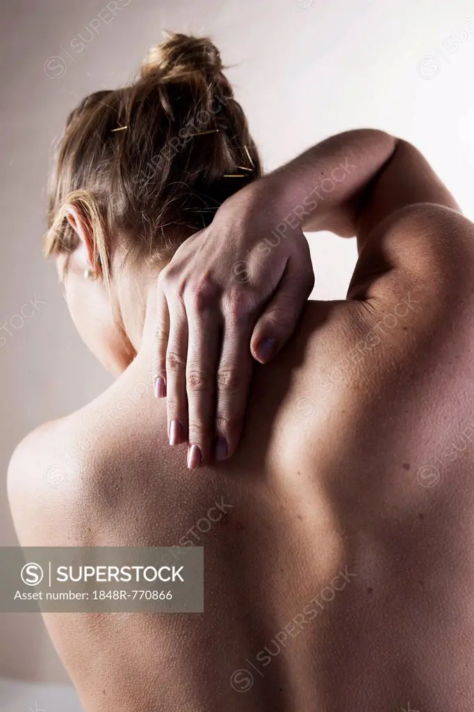 Young woman with neck pain, back view