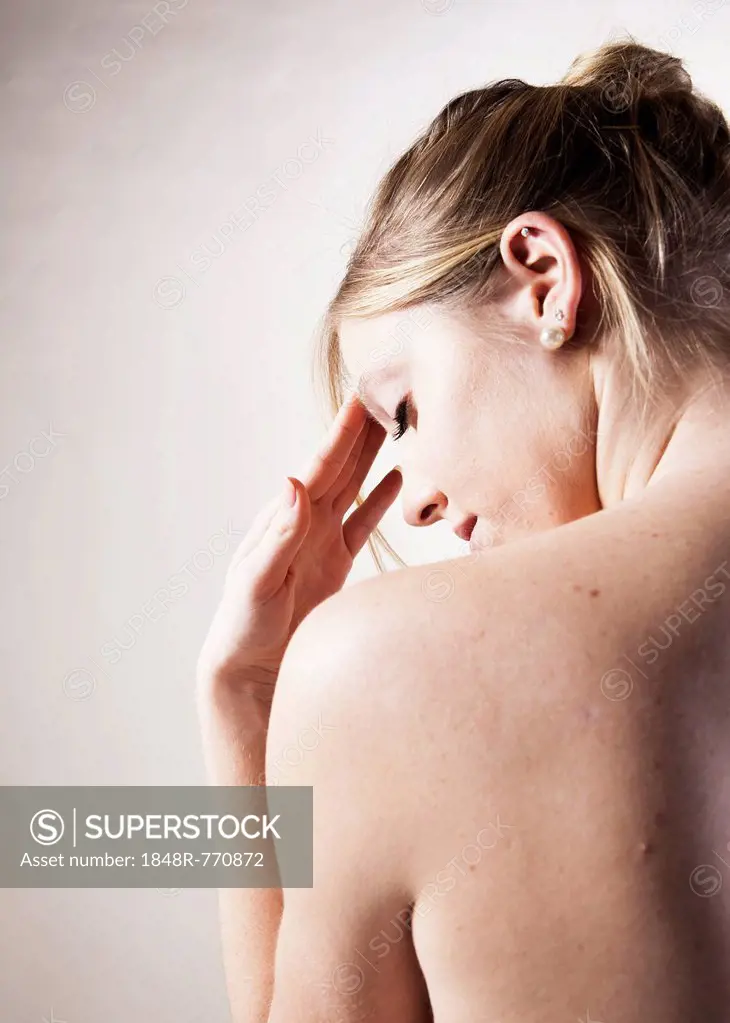 Young woman with a headache, bare back
