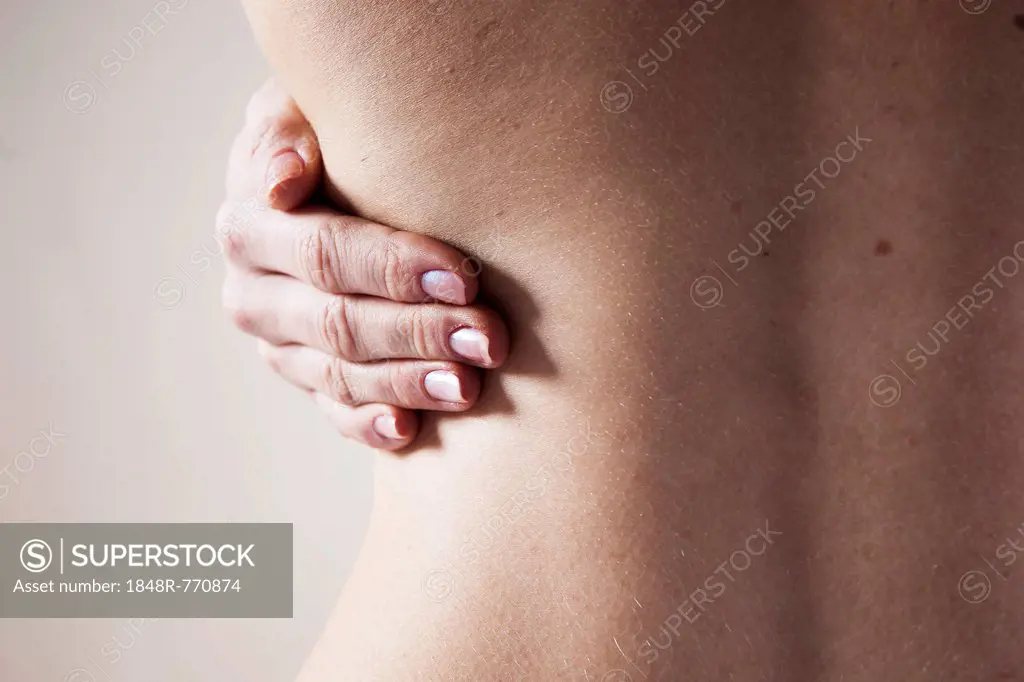 Bare back of a young woman with back pain