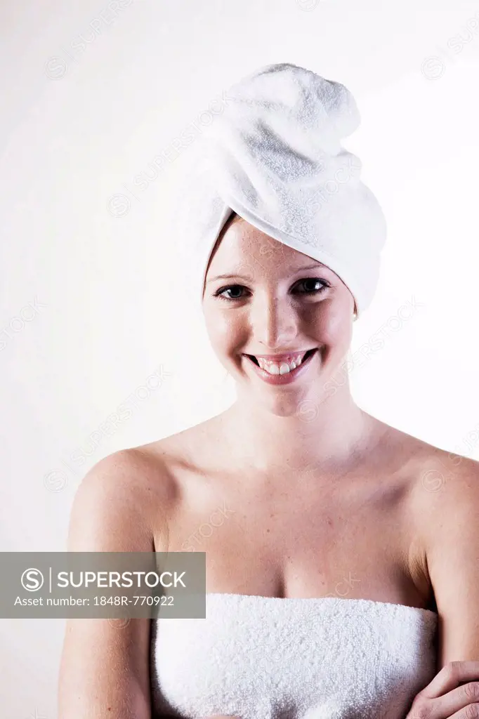 Portrait of a smiling young woman with a towel wrapped around her head