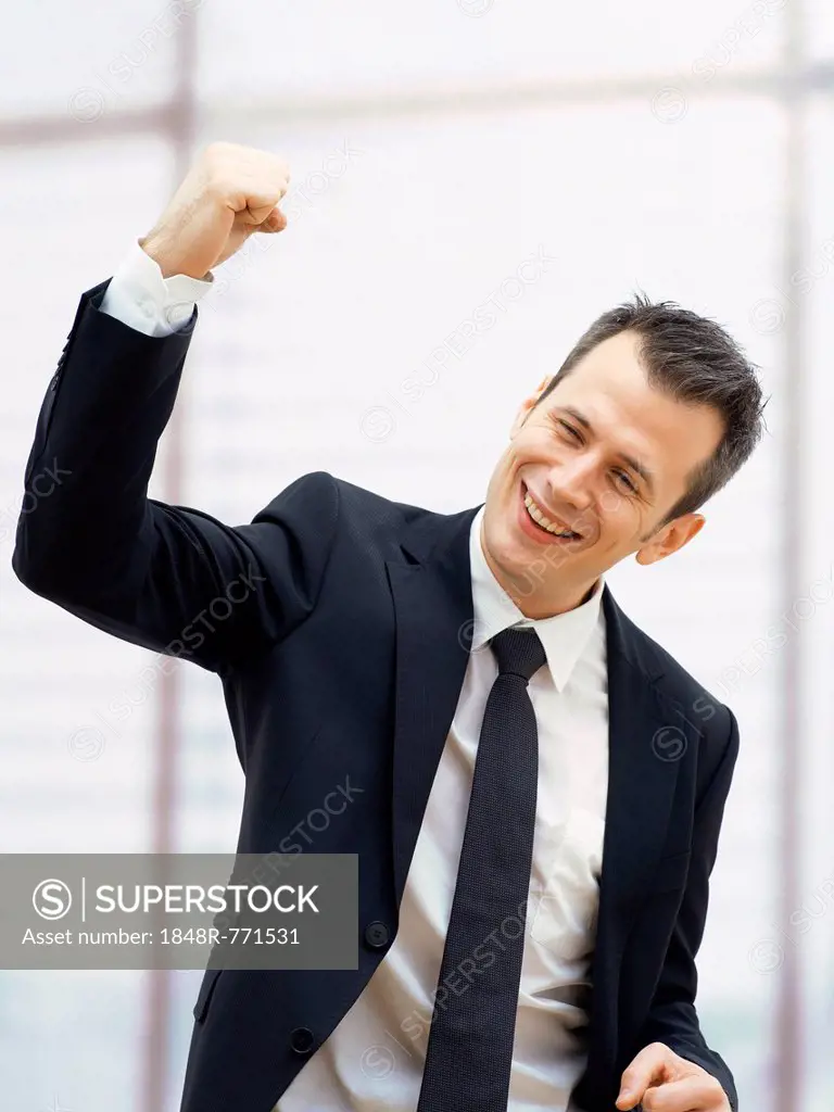 Businessman in an office cheering with a clenched fist