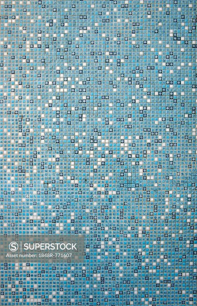 Mosaic wall with small white and turquoise tiles in a swimming pool