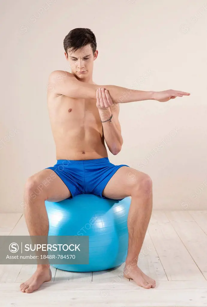 Young man doing stretching exercises, Mannheim, Baden-Württemberg, Germany