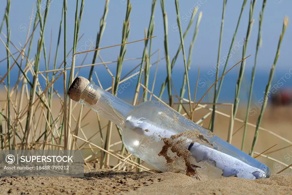Message in a bottle in sand on a beach, Georgioupolis, Crete, Greece
