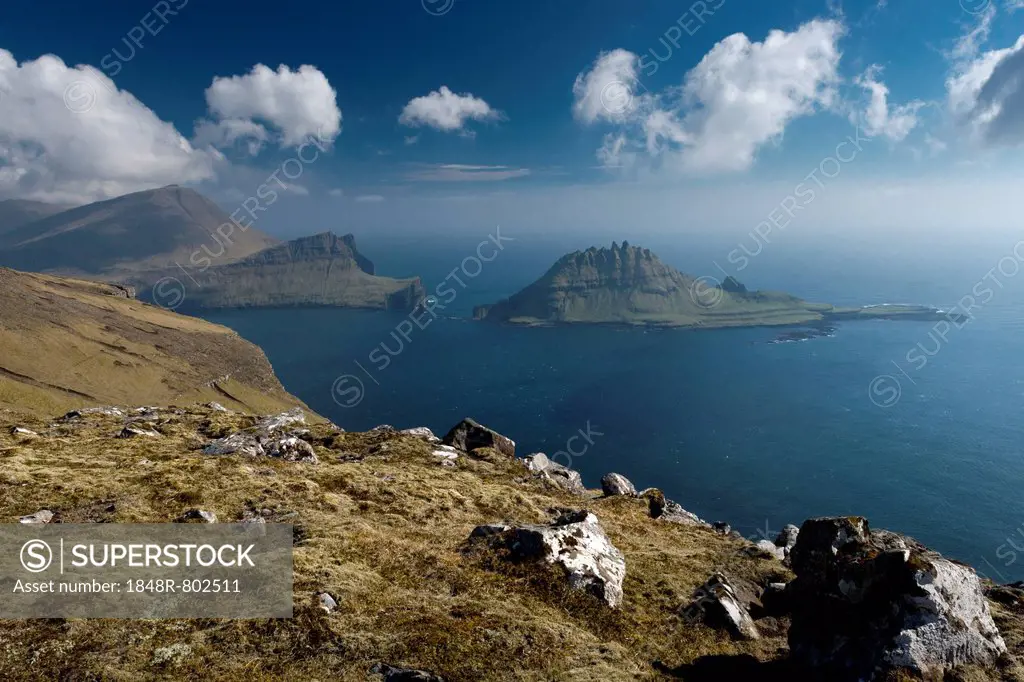 Rugged rocks of Tindhólmur seen from the hiking trail between Bøur and Gasadalur, Vágar, Faroe Islands, Denmark