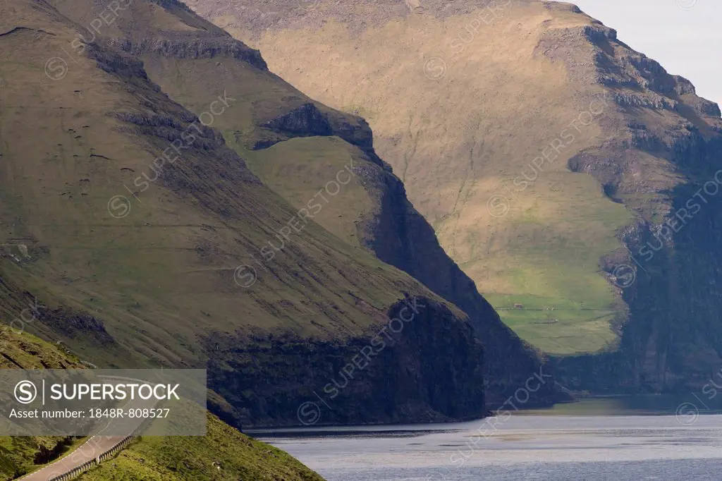 Road and mountains towering from the sea, Kalsoy, Norðoyar, Faroe Islands, Denmark