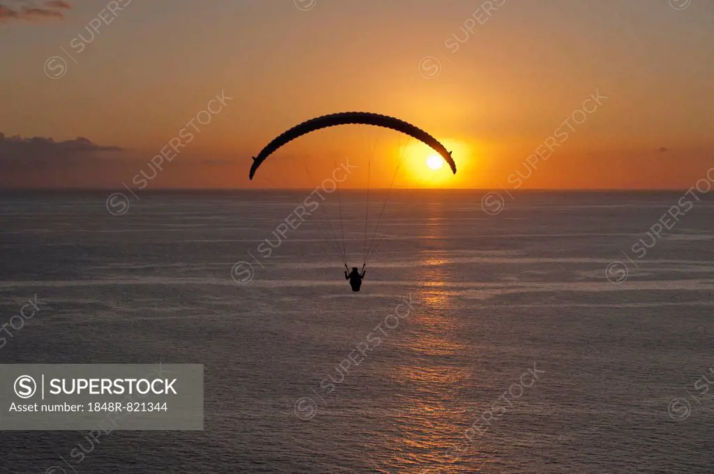 Paraglider over the Atlantic Ocean with sunset, Canary Islands, Spain