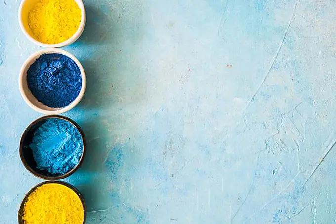 Yellow blue holi color powder bowls concrete painted background