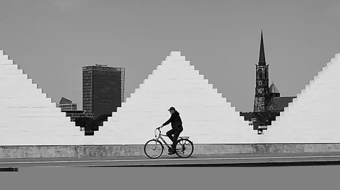 Cyclist in front of white wall, church and high-rise building behind, Hanseatic city, Bremen, Germany, Europe