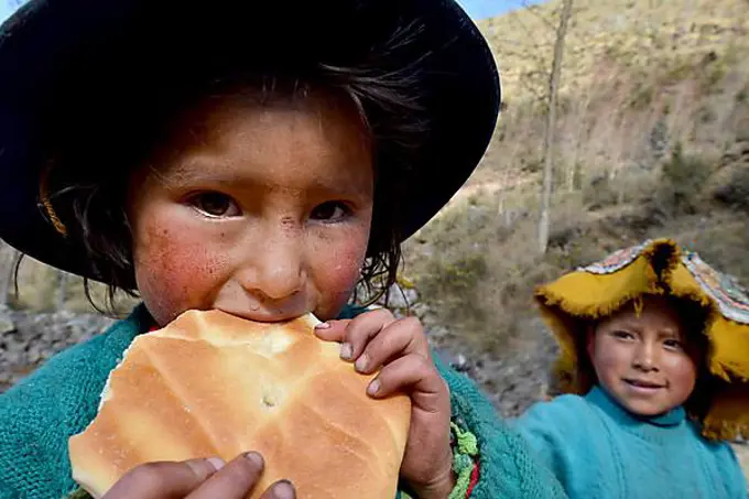 Native Peruvian girl eating bread, portrait, Cusco, Peru, South America