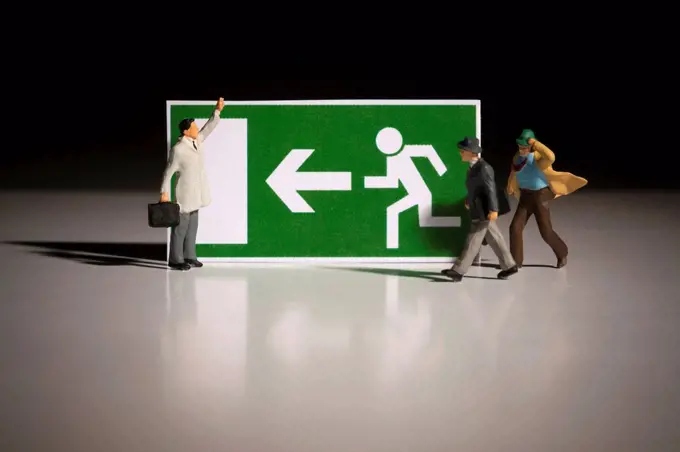Emergency exit direction sign with miniature business people figures, symbolic image recovery in the financial crisis, economic crisis, way out in tim...