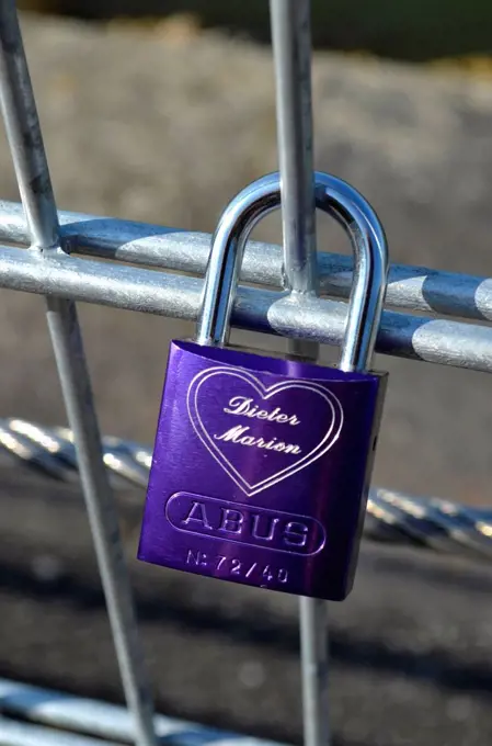 Single lilac padlock with names in a heart on a metal fence, Rhine River, Dusseldorf, North Rhine-Westphalia, Germany, Europe