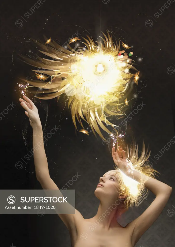 Woman reaching up to abstract glowing ball