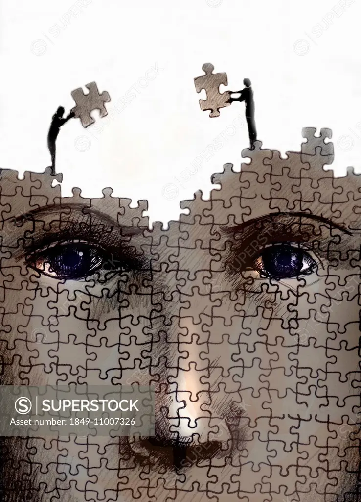 Man and woman working together on large jigsaw puzzle of human face