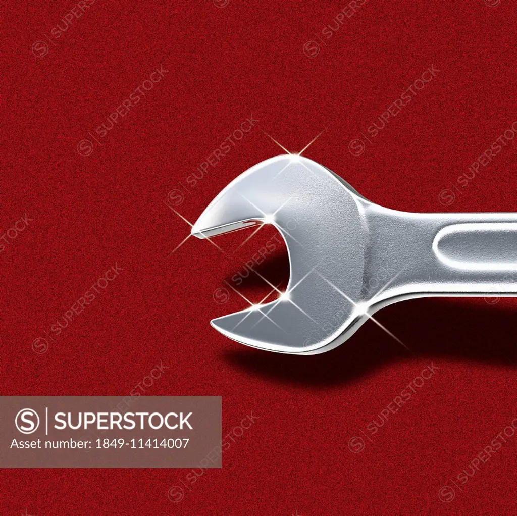 Shiny metal crescent wrench on red background