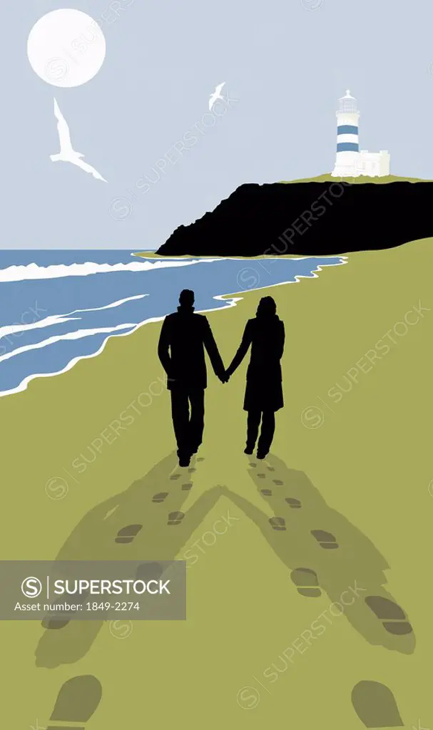 Footprints behind couple walking on sunny beach with lighthouse