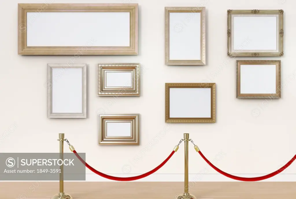 Empty picture frames behind cordon in art gallery