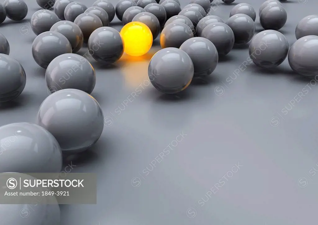 Glowing yellow ball among grey balls