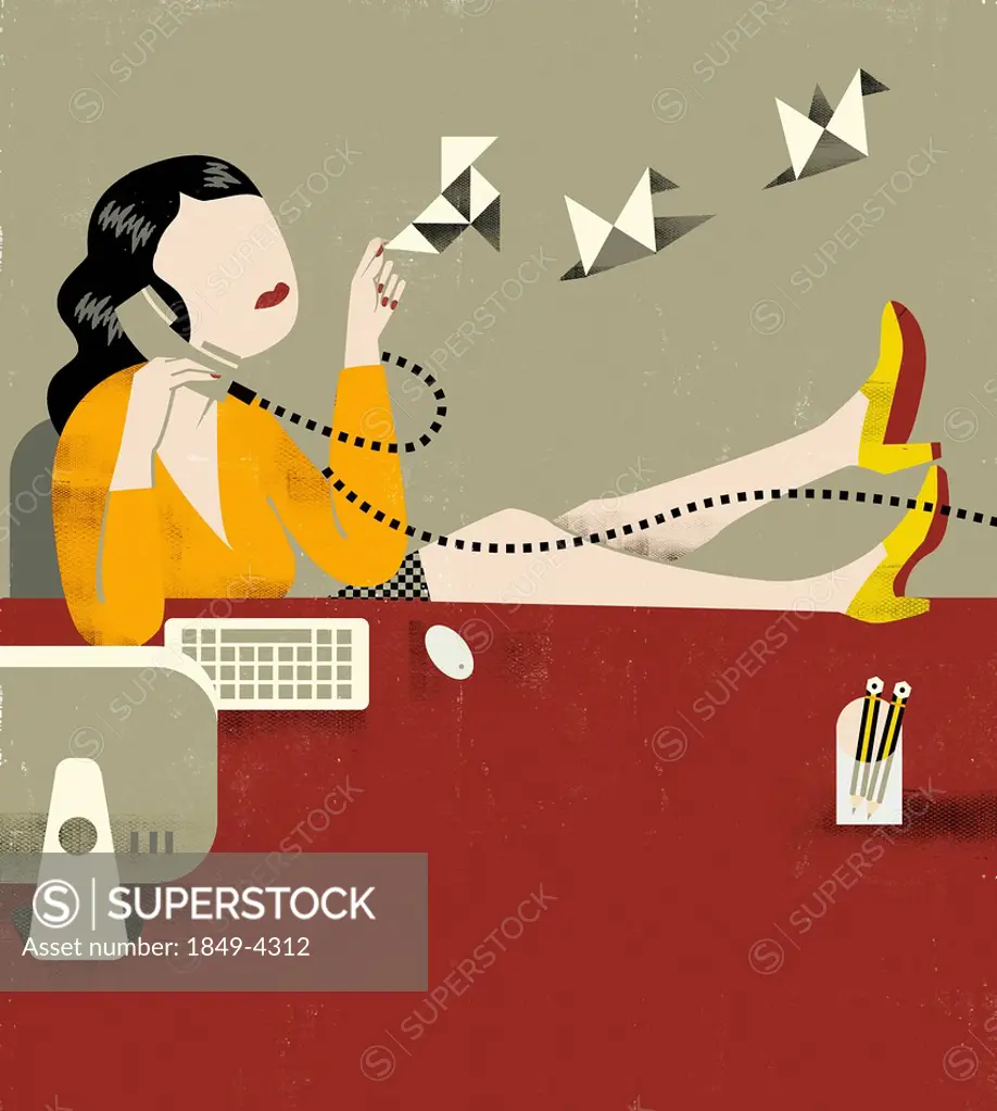 Businesswoman releasing origami birds and talking on telephone with feet up