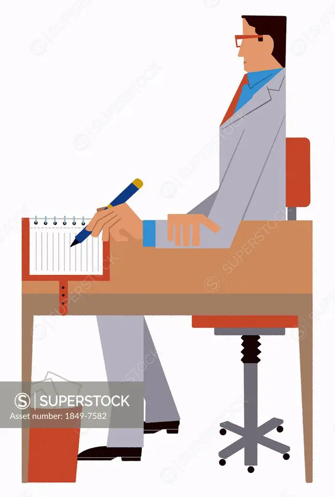 Businessman writing in notebook sitting at desk