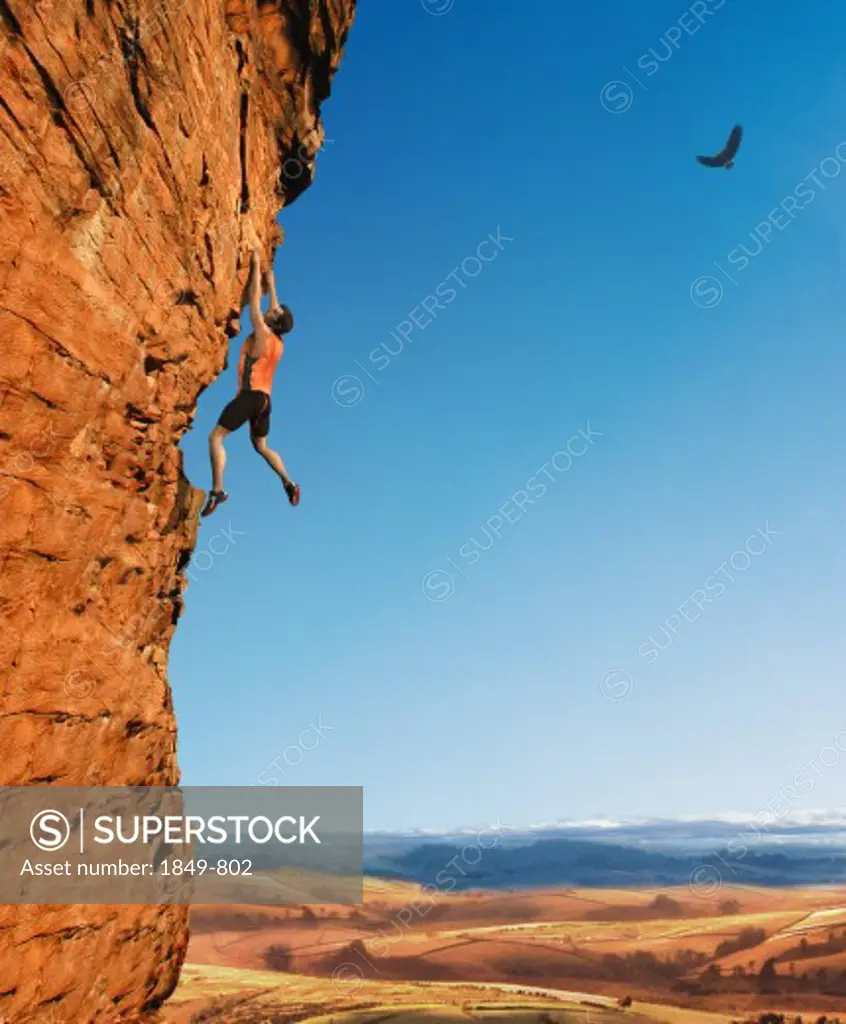 Rock climber dangling from cliff wall
