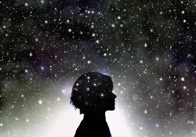 Silhouette of woman's head in galaxy of stars